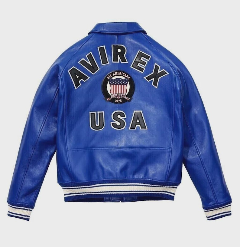 May include: A vibrant blue leather jacket with the word "AVIREX" arched across the shoulders. Below the logo is a patch with the words "ALL AMERICANS" and "USA" in white lettering. The jacket has white and blue striped cuffs.