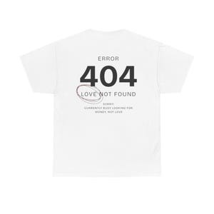 May include: White t-shirt featuring the text "ERROR 404 LOVE NOT FOUND". The number 404 is in bold black font, with a red and black oval design underneath. Below the oval, the text reads "SORRY! CURRENTLY BUSY LOOKING FOR MONEY, NOT LOVE."