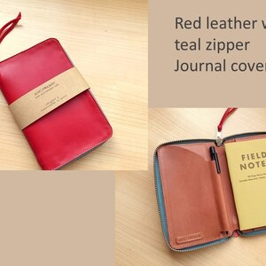 May include: A red leather journal cover with a teal zipper and a matching red leather pull tab. The cover features a brown paper band with the text "aceinmaker" and "designed & handcrafted in Spain". Inside, it holds a yellow Field Notes memo book.