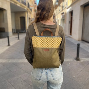 young girl with a mustard and green backpack walking down a European street