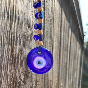 Evil Eye, Blue Turkish evil eye pendant with a woven rope band, car ornament,  hanging ornament garden art,  boho zen garden ornament