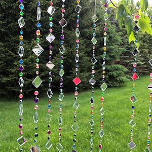 Beautiful hanging strings adorned with mirrors and colorful rhinestones that will hang from low tree branches.  They dangle freely and will move with the breeze, casting whimsical reflections throughout your outdoor space.  Whimsical colorful art