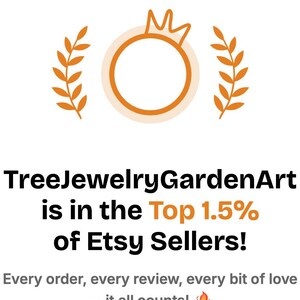 Puede incluir: Fondo blanco con el texto "Erank" en la parte superior. El texto "TreeJewelryGardenArt is in the Top 1.5% of Etsy Sellers!" se muestra debajo de un anillo dorado con una corona. Dos ramas de hojas doradas flanquean el anillo.