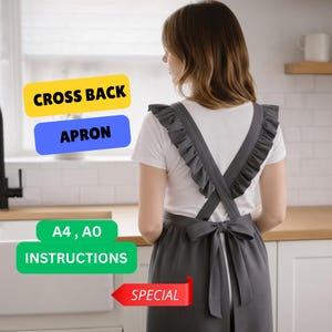 May include: A gray cross-back apron with ruffled straps and a bow at the waist. The apron is worn over a white t-shirt. Text on the image includes "CROSS BACK APRON", "A4, AO INSTRUCTIONS", and "SPECIAL".