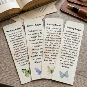 Könnte beinhalten: Vier rechteckige Lesezeichen aus Papier mit abgerundeten Ecken, jedes mit einem anderen Gebet und einer kleinen Aquarell-Schmetterlingsillustration. Der Text umfasst das 11th Step Prayer, Serenity Prayer, 3rd Step Prayer und 7th Step Prayer in schwarzer Schrift.