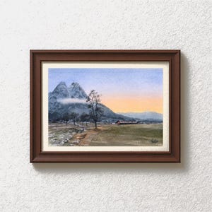 Peut inclure: Une peinture à l'aquarelle encadrée d'un paysage de montagne. L'œuvre représente une chaîne de montagnes avec un arbre au premier plan, un champ et un ciel coloré. Le cadre est de couleur marron foncé.