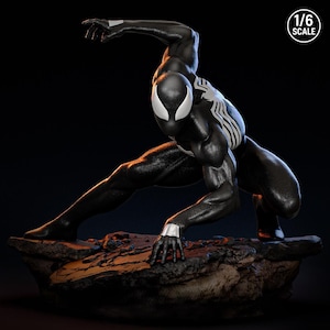 May include: A black and white Spider-Man action figure in a crouching pose, set on a rocky base. The figure has white accents on the eyes, hands, and spider emblem. The text "1/6 SCALE" is in the upper right corner.