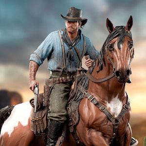 May include: A detailed figurine of a cowboy on horseback, set against a desert backdrop. The cowboy wears a blue shirt, hat, and holds a gun. The horse is brown and white. A "Wanted" poster is visible.