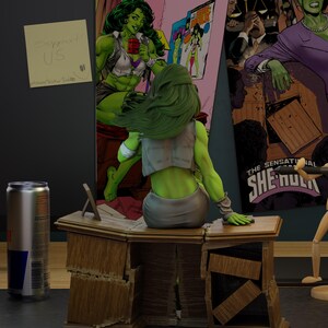May include: A She-Hulk figurine sits on a wooden desk, with a Red Bull can and comic book art in the background. The desk is distressed, and a sticky note reads "Support US". The scene is a comic book-themed display.