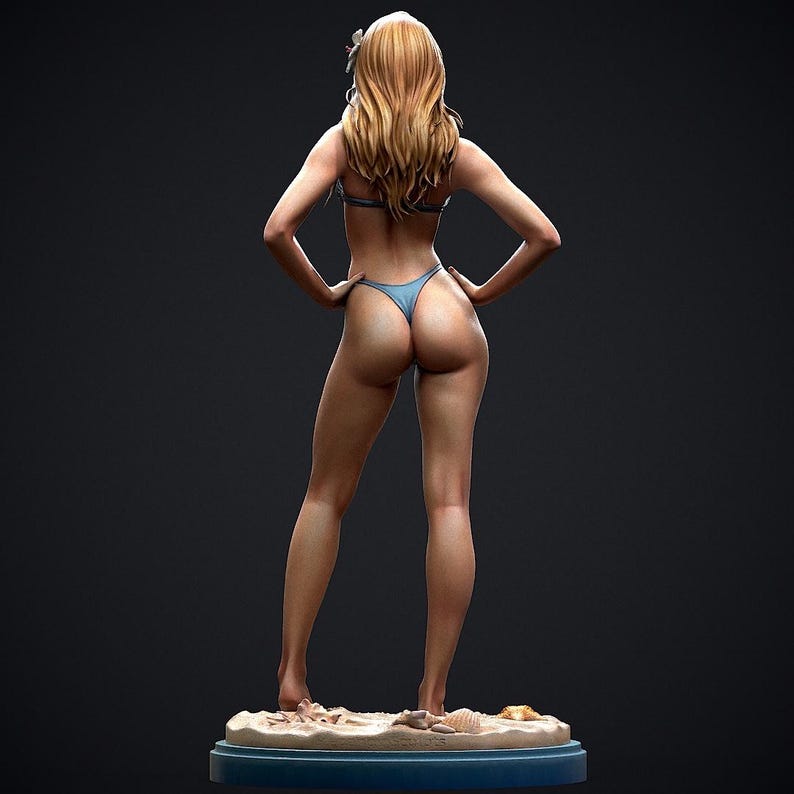 May include: A figurine of a person in a blue bikini, standing with hands on hips. The figure has long blonde hair and is posed on a sandy base with seashells. The background is a dark gray.