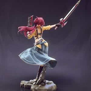May include: A detailed figurine of a character in a dynamic pose, holding a sword and a weapon. The figure has long, flowing red hair and is dressed in a yellow top, blue skirt, and brown boots. The base is a rocky structure.