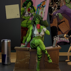 May include: A green She-Hulk figurine holding a red mug, seated on a wooden desk. The figurine is wearing a white top, grey vest, and black-striped leggings. A Red Bull can and a comic book poster are in the background.