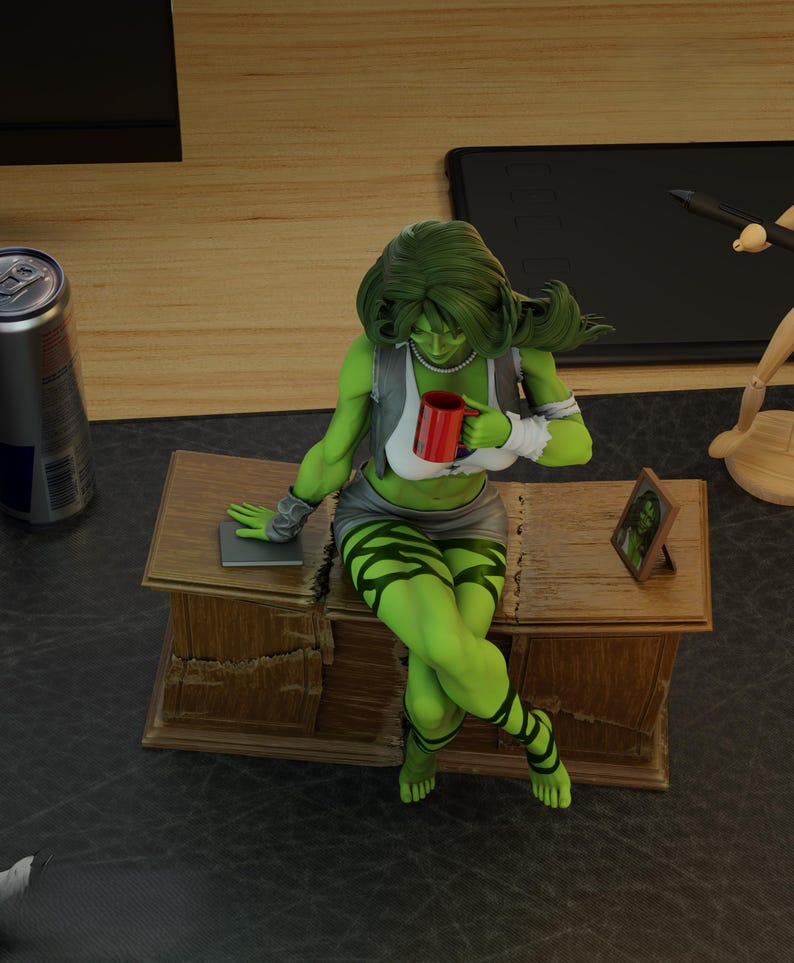 May include: A green She-Hulk figurine seated on a wooden desk, holding a red mug. She wears a grey vest, white top, and a short skirt. Her legs are adorned with green stripes. A framed picture and a can are also visible.