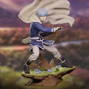 May include: A figurine of a character in a blue and white outfit, holding a sword. The figure has light blue hair and a white cape. It stands on a rocky base with small blue flowers and green grass. The background is a blurred landscape.