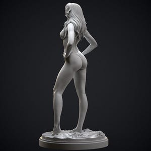 May include: A gray sculpture of a person in a swimsuit, standing with one hand on their hip. The figure has long hair and is posed on a circular base. The sculpture is detailed and appears to be made of a solid material.