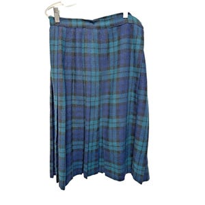 May include: A pleated skirt in a blue, teal, and black plaid pattern. The skirt is hanging on a hanger against a white background. The fabric appears to be a woven material.