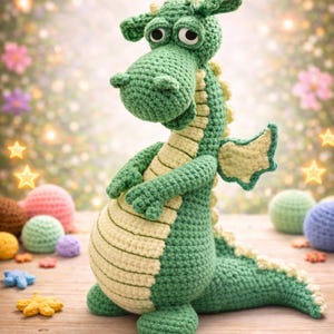 May include: A handmade green crochet dragon with a light green belly and wings. The dragon has large, round eyes and is posed on a wooden surface. Other crochet toys and decorations are in the background.