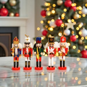 May include: Five colorful wooden nutcrackers with detailed uniforms and accessories stand on a reflective surface. The nutcrackers are red, blue, green, and white, with gold accents. A Christmas tree with ornaments and lights is in the background.
