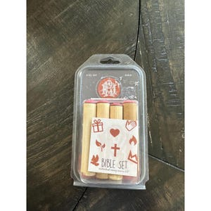 Pode incluir: Um pacote de plástico transparente contendo um conjunto de selos da Bíblia. O conjunto inclui selos de madeira com vários símbolos religiosos, como uma cruz, um coração e uma pomba. O texto "BIBLE SET" é impresso na etiqueta. Tamanho do selo individual 1,27 cm.
