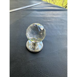 Tirador de puerta vintage de cristal facetado con base de cromo pulido y corte de diamante transparente.