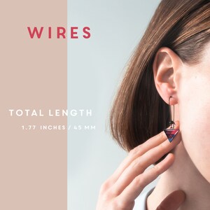 K&ouml;nnte beinhalten: Das Bild zeigt den Text 'Wires'. Ein Paar Ohrringe mit einem geometrischen Dreiecksdesign in Rot-, Blau- und Schwarzt&ouml;nen. Die Ohrringe sind 1,77 Zoll oder 45 mm lang.