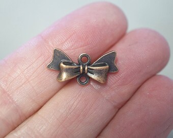 10 Small Metal Antique Copper Colour Bow Charms/Connectors - 20mm