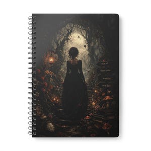 May include: A spiral-bound notebook featuring a dark, atmospheric illustration of a person in a long black dress standing on stone steps in a forest. The scene includes a full moon, glowing lanterns, flowers, mushrooms, and a sign reading Not all those who wander are lost.