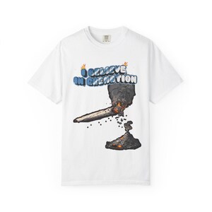 May include: White t-shirt featuring a graphic of a burning joint with smoke and the text "I BELIEVE IN CREMATION" in blue and orange. The design includes flames and ash.