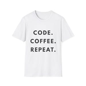 Può includere: T-shirt bianco con la scritta "CODE. COFFEE. REPEAT." in grassetto nero. La maglietta ha un girocollo e maniche corte. Il testo è centrato sul davanti.