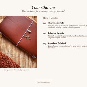 May include: A brown leather journal with a white string closure and decorative charms. The text "Your Charms" and "Hand-selected for your cover, always included" are displayed. The journal is shown with a knitted brown scarf.