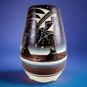 Peut inclure: Un vase en céramique foncé fait à la main avec un design unique. Le vase présente un paysage avec un ciel nocturne, des étoiles et des formes géométriques. La palette de couleurs comprend le noir, le blanc, le marron et le bleu. Le vase mesure environ 30 cm de haut.