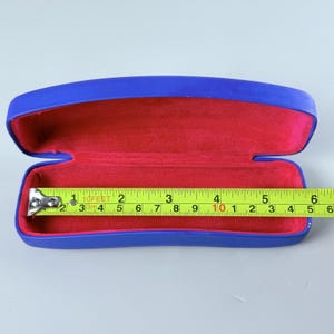 Estuche rígido azul para gafas Ray-Ban con interior rojo y acabado mate tipo concha. imagen 9
