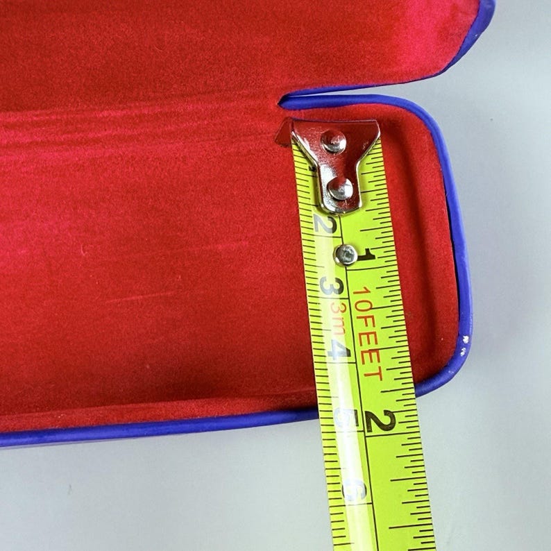 Estuche rígido azul para gafas Ray-Ban con interior rojo y acabado mate tipo concha. imagen 10