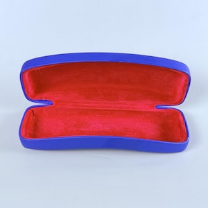 Estuche rígido azul para gafas Ray-Ban con interior rojo y acabado mate tipo concha. imagen 3