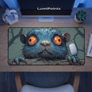 Puede incluir: Alfombrilla de ratón rectangular con una ilustración de dibujos animados de un roedor azul con grandes ojos naranjas. El roedor se asoma por encima de un borde, con ramas de árboles en el fondo. La alfombrilla está sobre un escritorio de madera.