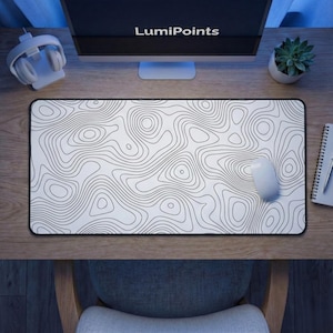 May include: A rectangular white desk mat with a black topographic map design. A white computer mouse rests on the mat. The text "LumiPoints" is visible on the computer monitor.
