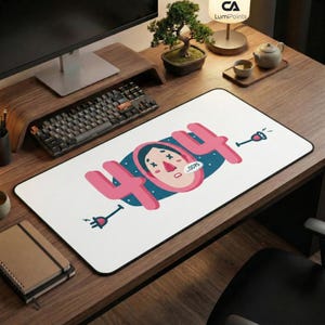May include: White rectangular mousepad with a black border featuring a pink "404" design and a cartoon face. The design includes a blue background and two electrical plug illustrations. A keyboard and monitor are visible in the background.