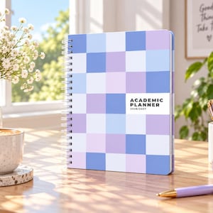 Peut inclure: Un agenda scolaire à reliure spirale avec un motif à carreaux bleu clair, lavande et blanc. La couverture présente le texte ACADEMIC PLANNER 2026/2027 en police noire sur un fond rectangulaire blanc centré sur la couverture avant.