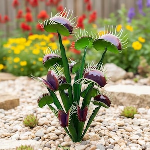May include: A metal sculpture of a Venus flytrap plant with green leaves and purple traps. The sculpture is placed in a garden bed with small rocks and other plants in the background. The flytrap has white, spiky teeth.