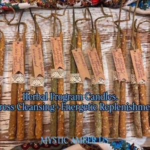 May include: A collection of herbal program candles with various herbs, each adorned with a tag. The candles are in shades of brown and green, with a lace detail. Text on the image reads "Herbal Program Candles. Express Cleansing + Energetic Replenishment."