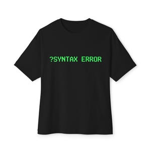 May include: Black t-shirt with the text "?SYNTAX ERROR" in green, a reference to a coding error. The shirt has short sleeves and a crew neck. The text is in a pixelated font.