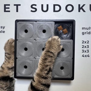 May include: A gray pet puzzle with the text "PET SUDOKU" and "easy scalable". The puzzle has multiple grids: 2x2, 2x3, 3x3, and 4x4. A cat's paws are interacting with the puzzle.