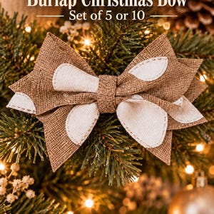 May include: A decorative bow made of brown burlap with white fabric accents, featuring stitched edges. The text Burlap Christmas Bow Set of 5 or 10 is displayed above the bow. The bow has a layered design with a central knot and pointed ends.