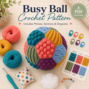 May include: A crochet pattern PDF titled Busy Ball Crochet Pattern featuring a multi-colored crocheted ball with various textures, yarn skeins in coral, yellow, and teal, a crochet hook, stitch markers, and a stitch reference card with diagrams.