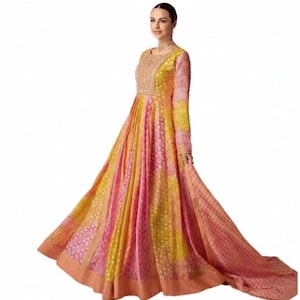 May include: A long, flowing gown in shades of yellow, pink, and peach. The dress features a detailed bodice with intricate embroidery and a full skirt with a patterned design. The sleeves are long, and the dress has a train.