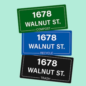 May include: Three rectangular signs with white text reading 1678 WALNUT ST. The top sign is green with the word COMPOST, the middle sign is blue with the word RECYCLE, and the bottom sign is black with the word TRASH. Each sign has a white border.