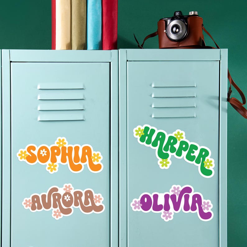 May include: Light blue lockers with colorful name stickers. The stickers feature the names Sophia, Aurora, Harper, and Olivia in various colors and floral designs. A vintage camera sits on top of the lockers.