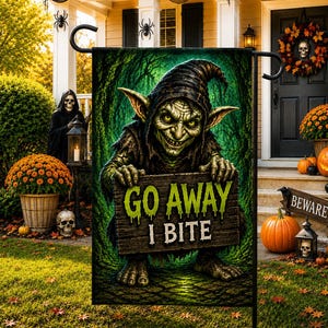 Könnte beinhalten: Eine rechteckige Gartenflagge mit einem grünhäutigen Kobold mit spitzen Ohren und dunkler Kapuze, der ein Holzschild mit der Aufschrift "GO AWAY I BITE" in hellgrünen und weißen Buchstaben vor einem dunklen, strukturierten Waldhintergrund hält.