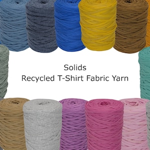 May include: A collection of colorful recycled t-shirt fabric yarn in various shades, including blue, yellow, brown, and pink. The image displays multiple spools of yarn, with the text "Solids Recycled T-Shirt Fabric Yarn" in the center.