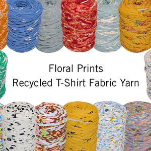 以下が含まれることがあります： さまざまな花柄のカラフルなリサイクルTシャツ生地糸のコレクション。オレンジ、青、赤、黄、緑の色合いの糸が複数表示され、「Floral Prints Recycled T-Shirt Fabric Yarn」の文字が表示されています。